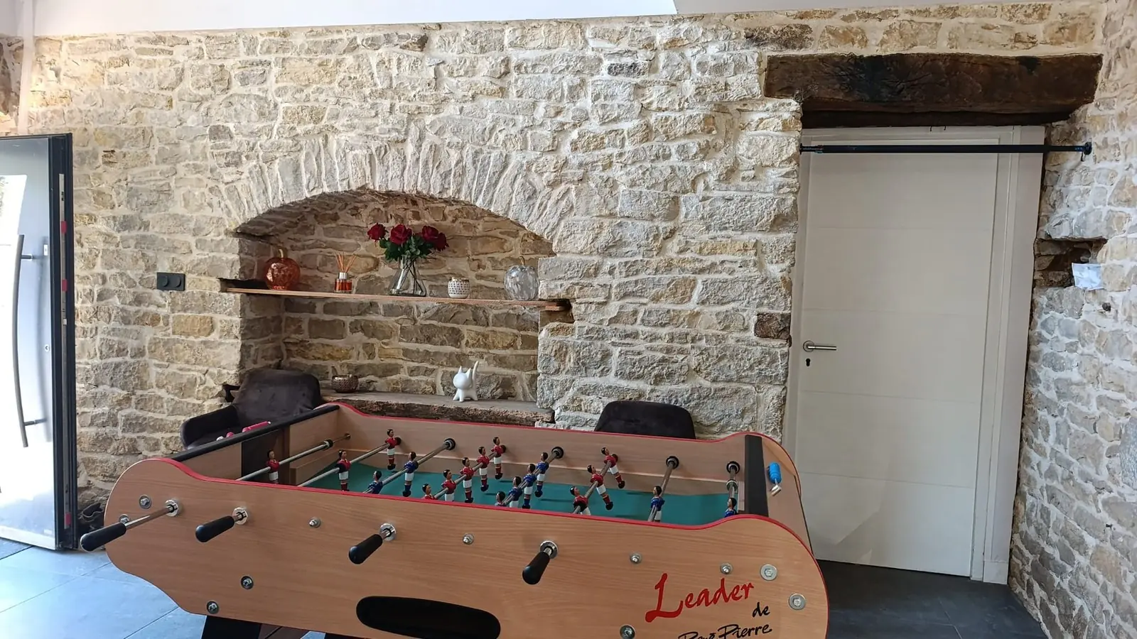 L'entrée, son mur en pierre et le baby-foot